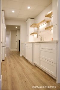 Basement kitchen with white cabinetry, wood accents, and natural light for a warm, modern ADU space